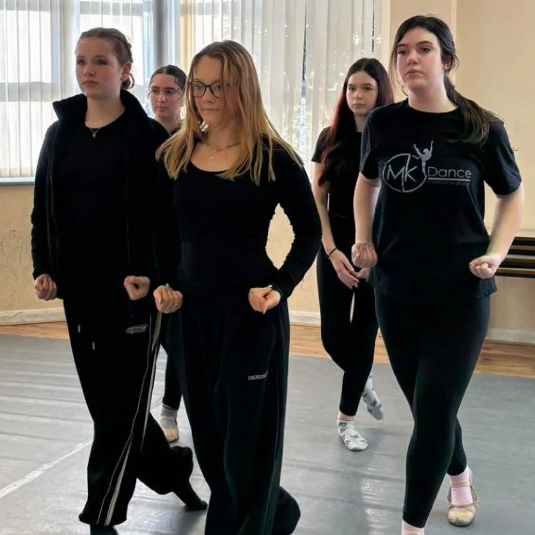 Dancers dressed in black during a class in the hall