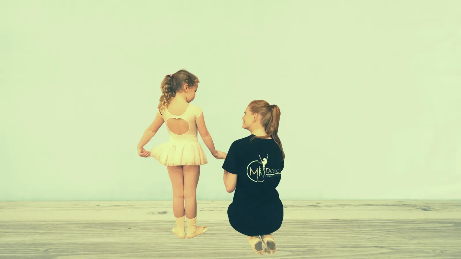 Two young dancers in the studio, one in a yellow leotard