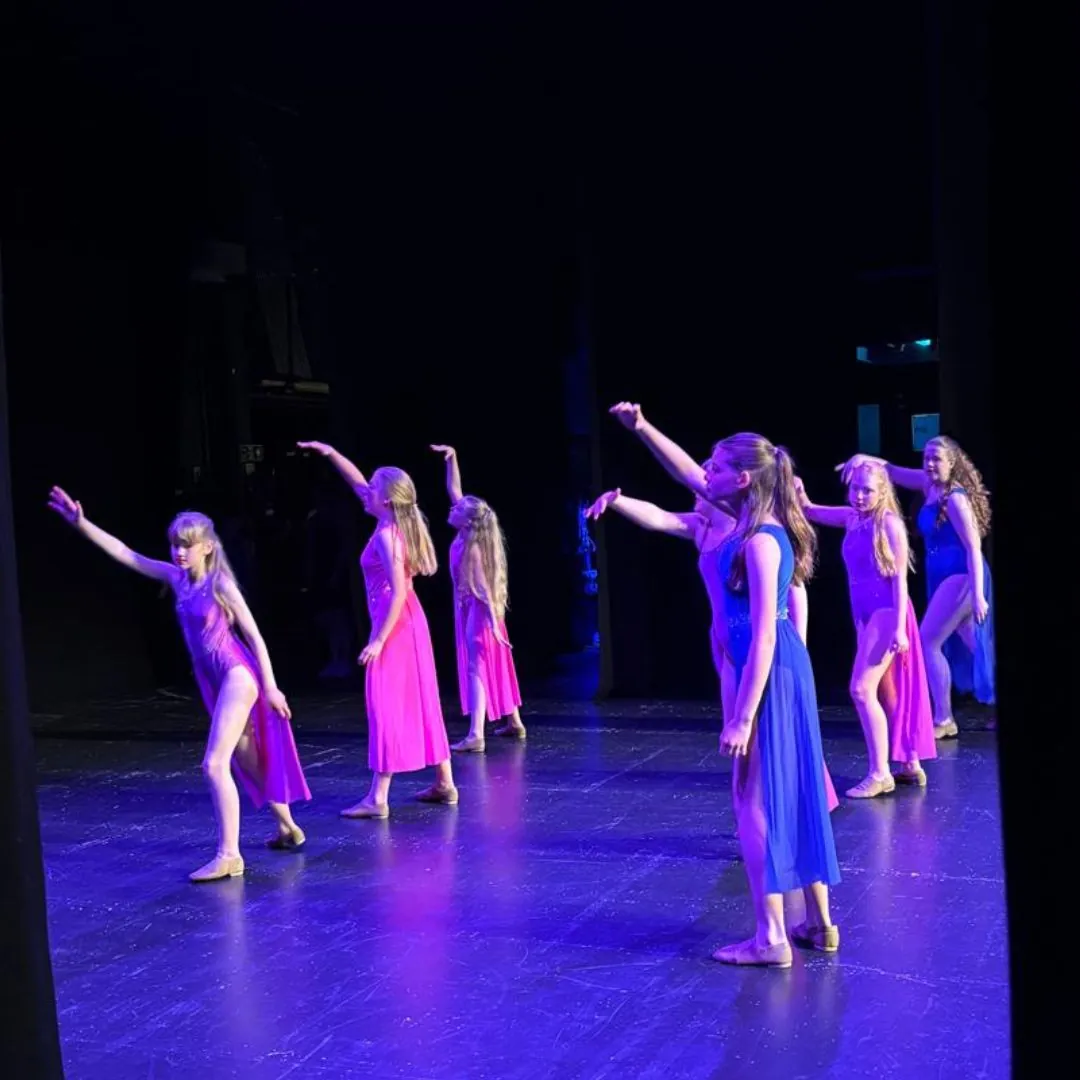 MK Associates on stage under blue lights at the Theatre Royal Brighton