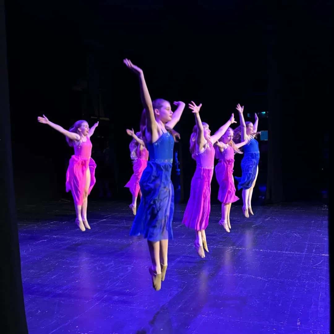 MK Associates performing in purple and pink costumes at the Theatre Royal Brighton