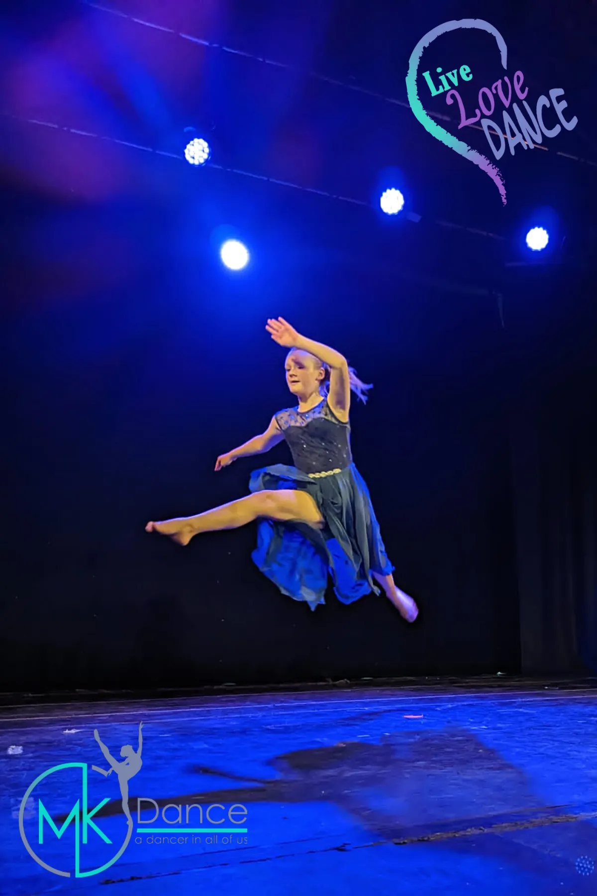 A modern dancer leaping on stage under blue lighting